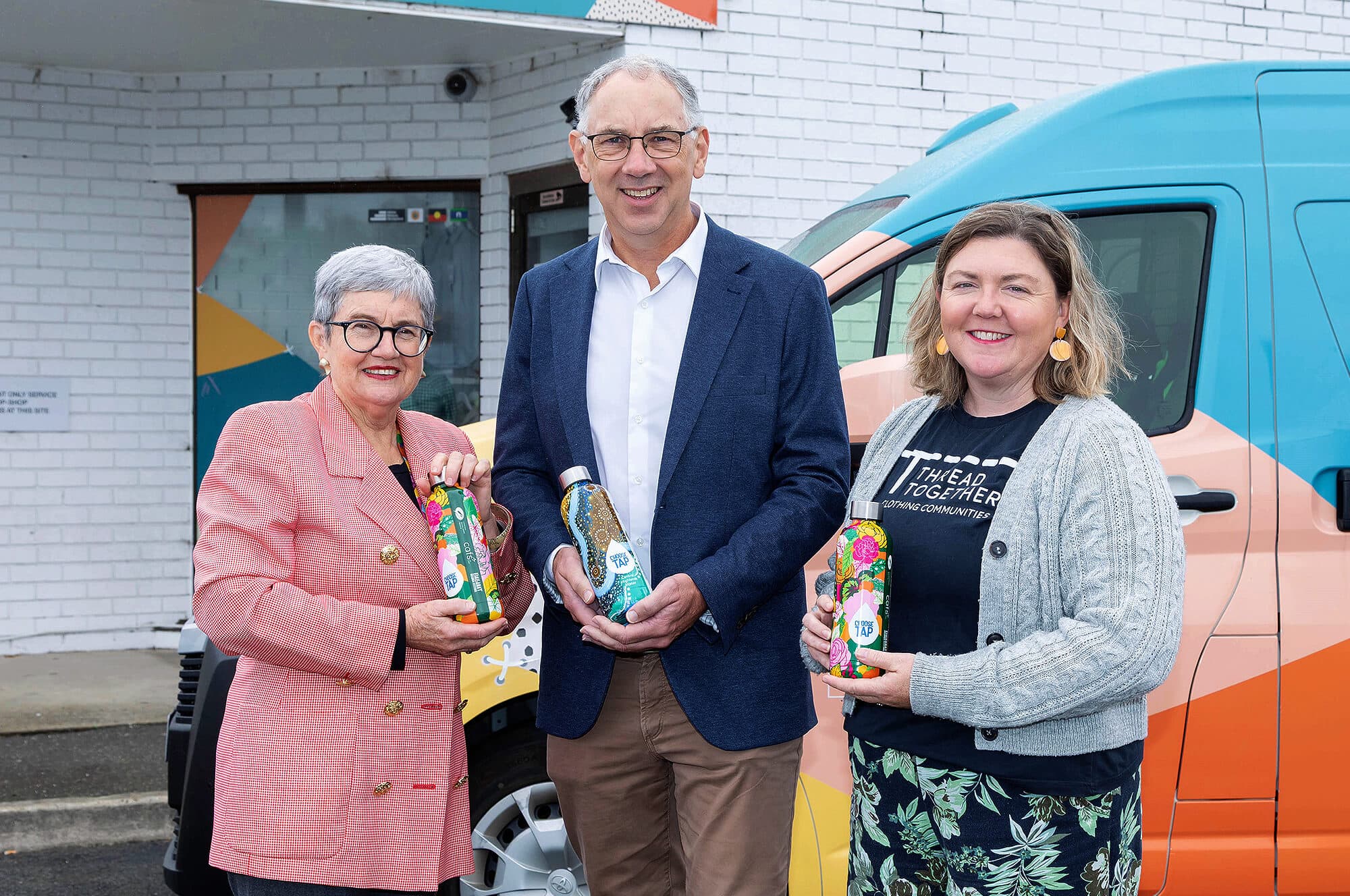 Photo of Cafs CEO, Wendy Sturgess, Central Highlands Water Managing Director, Jeff Haydon and Thread Together Program and Volunteer Lead, Sally Bennett, each holding a Central Highlands water bottle to promote donations to Cafs