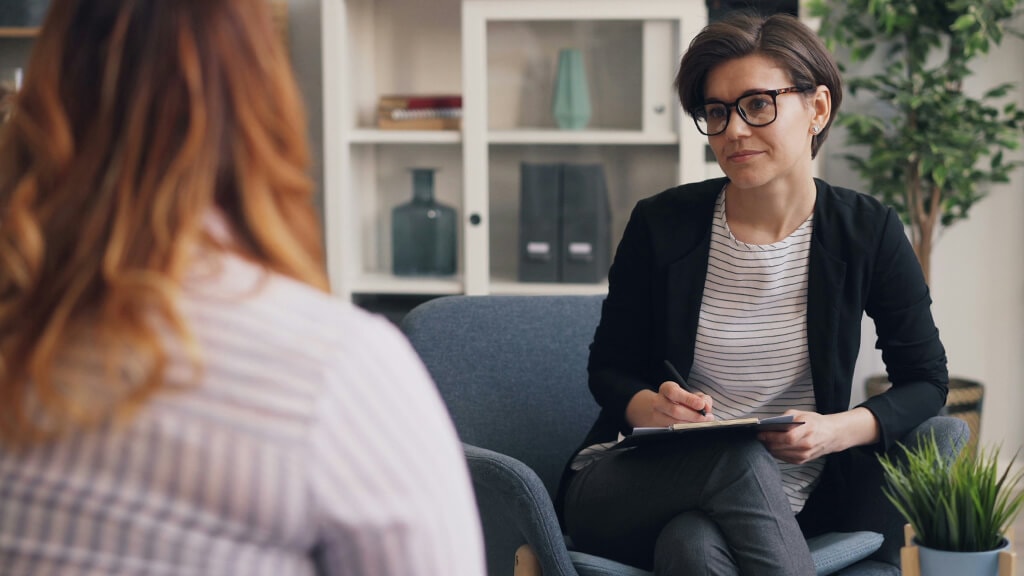 Woman with red hair in counselling session with female therapist