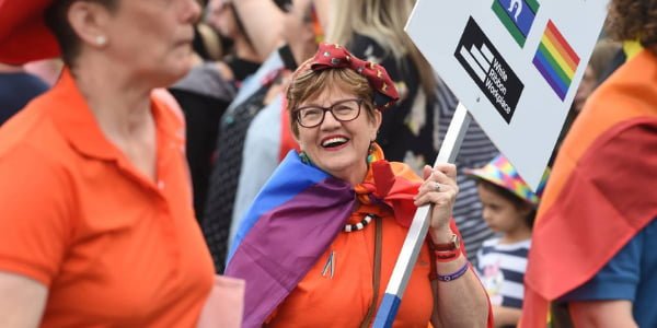 Woman happily carrying a pride sign