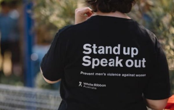 Woman wearing a white ribbon shirt with sign
