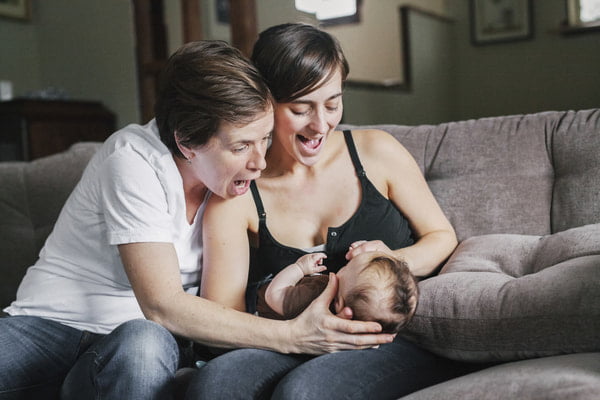 Two people playing with their baby
