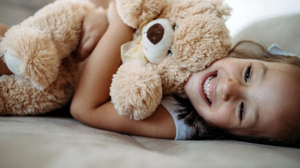 Young girl holding her teddy bear as part of the foster care enquiry form